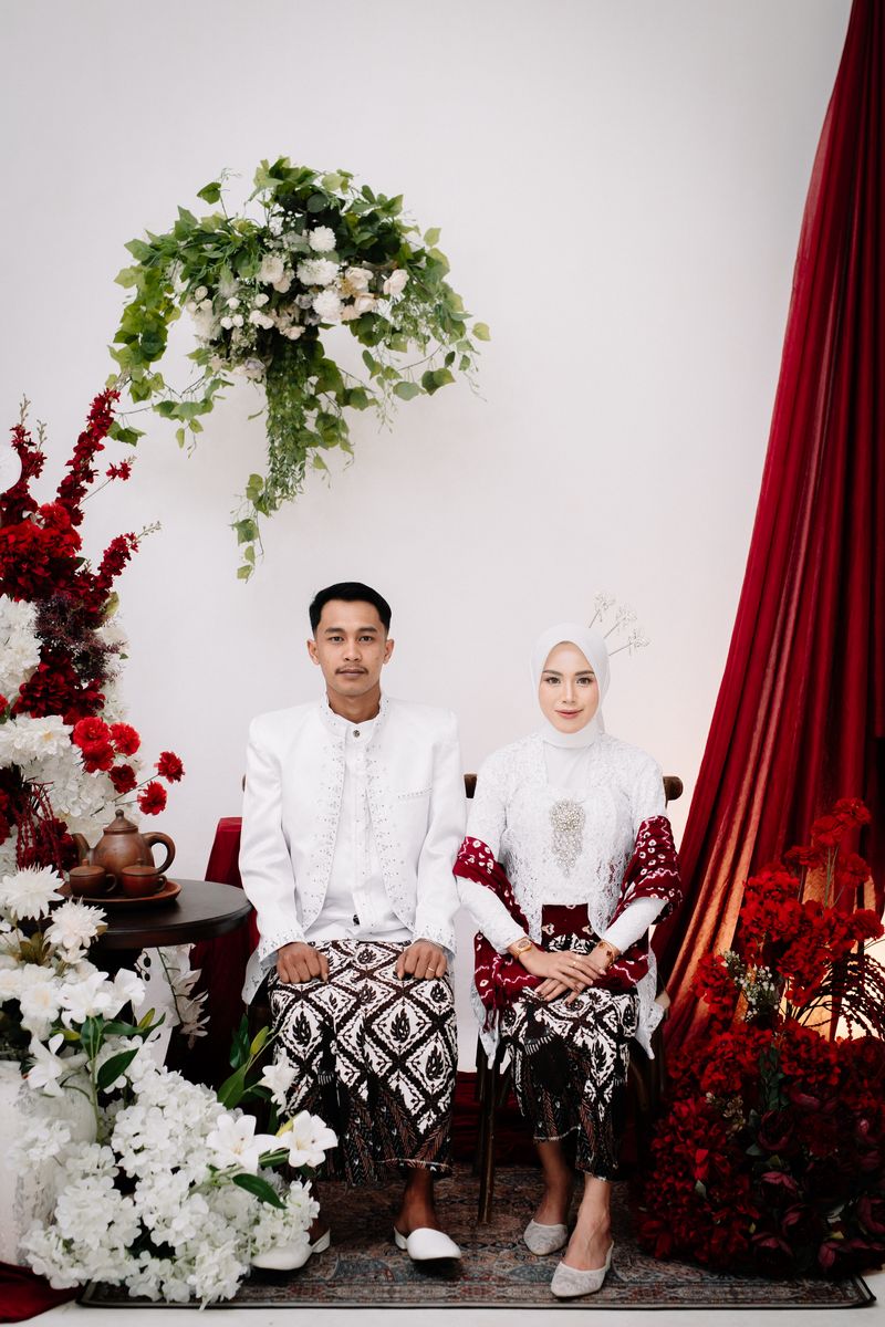 Rahardiyan dan Safrina duduk berdampingan mengenakan busana adat putih